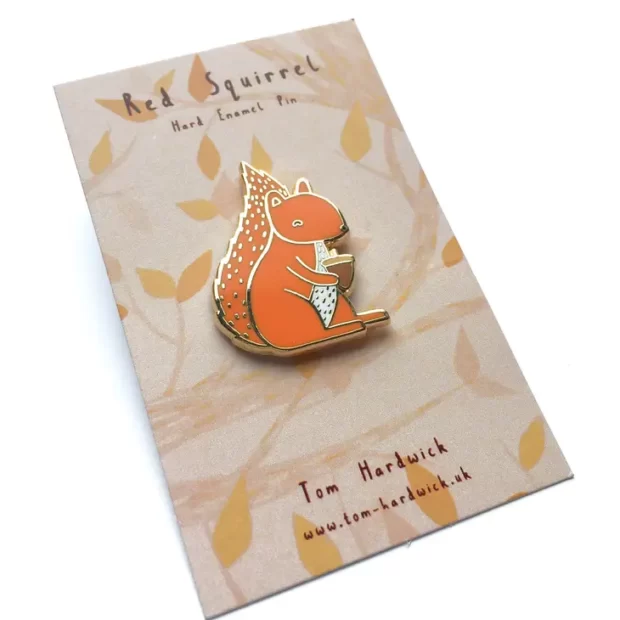 Red Squirrel enamel pin badge on a patterned backing card with the artists name and animal name.